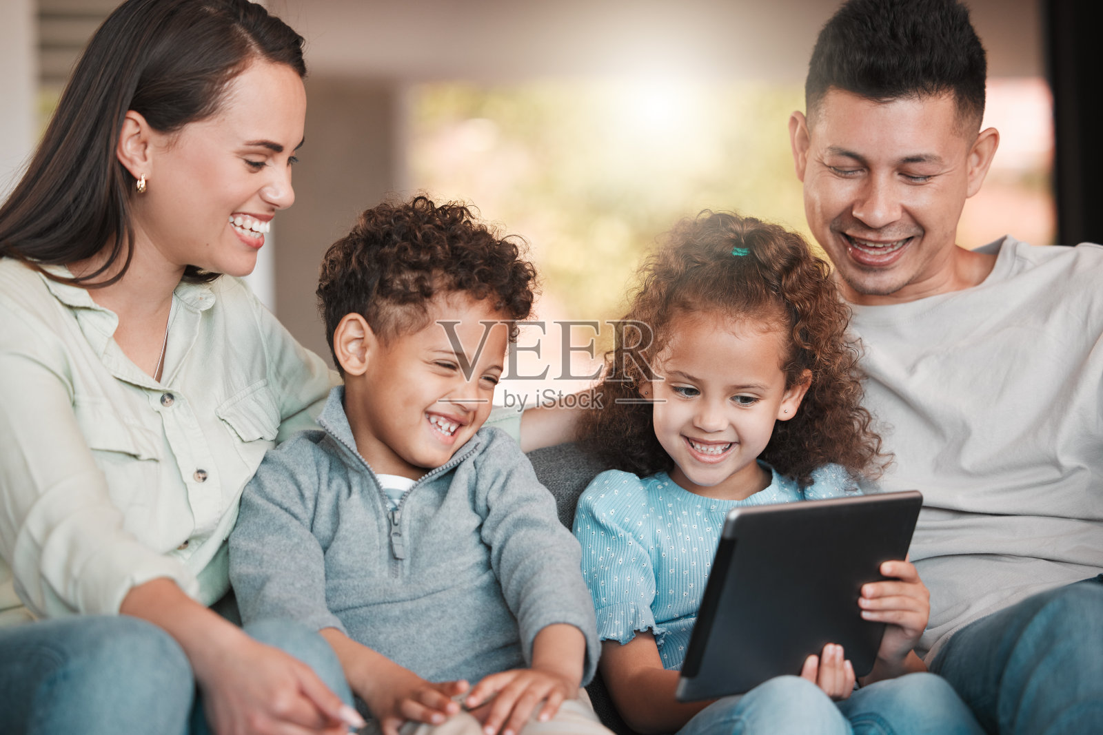 一个年轻的家庭在家里使用数码平板电脑照片摄影图片