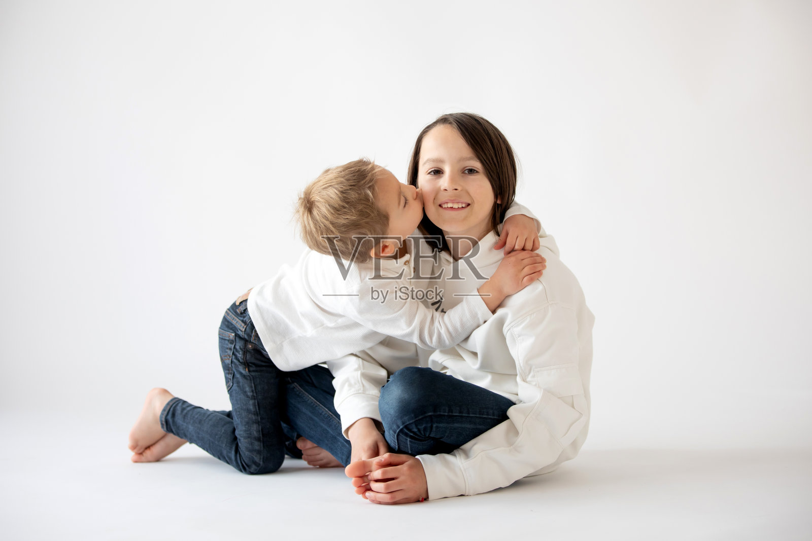 可爱时尚的蹒跚学步的孩子和哥哥，白色背景的白衬衫男孩，家庭孩子的肖像照片摄影图片