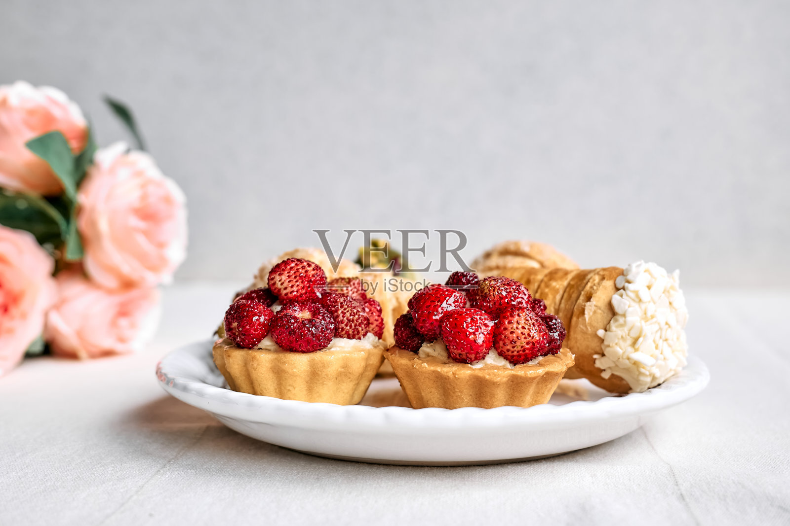 美味的馅饼、甜点、什锦糕点。迷你馅饼，奶油馅和草莓馅。美味的糕点甜点派的特写。照片摄影图片