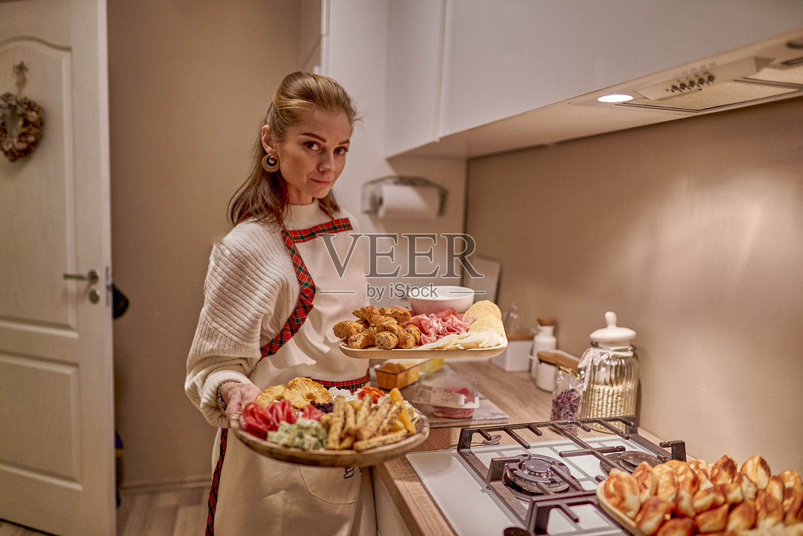 年轻漂亮的女人在厨房里为节日晚餐做饭。照片摄影图片