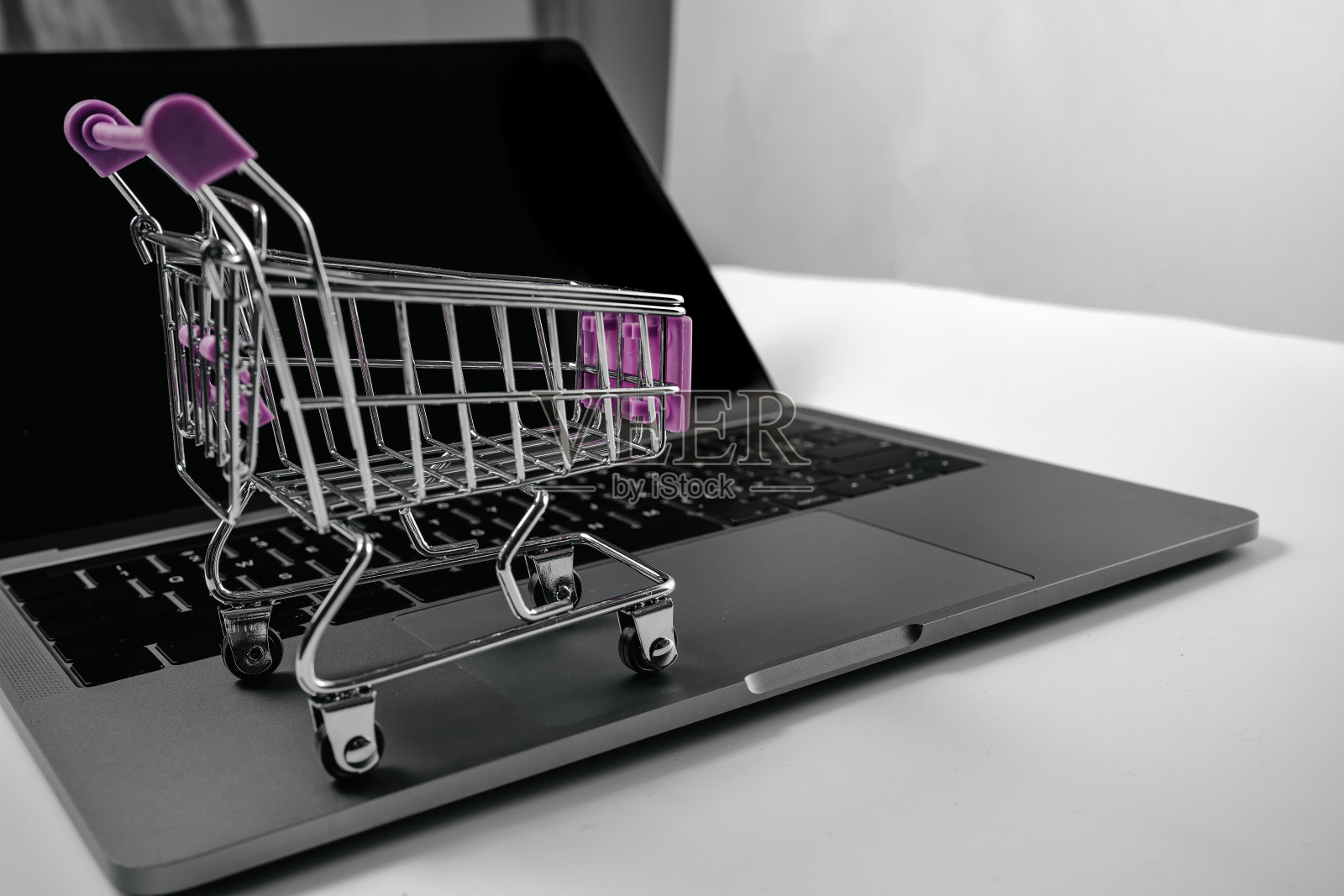 电脑和购物车在白色的背景板照片摄影图片