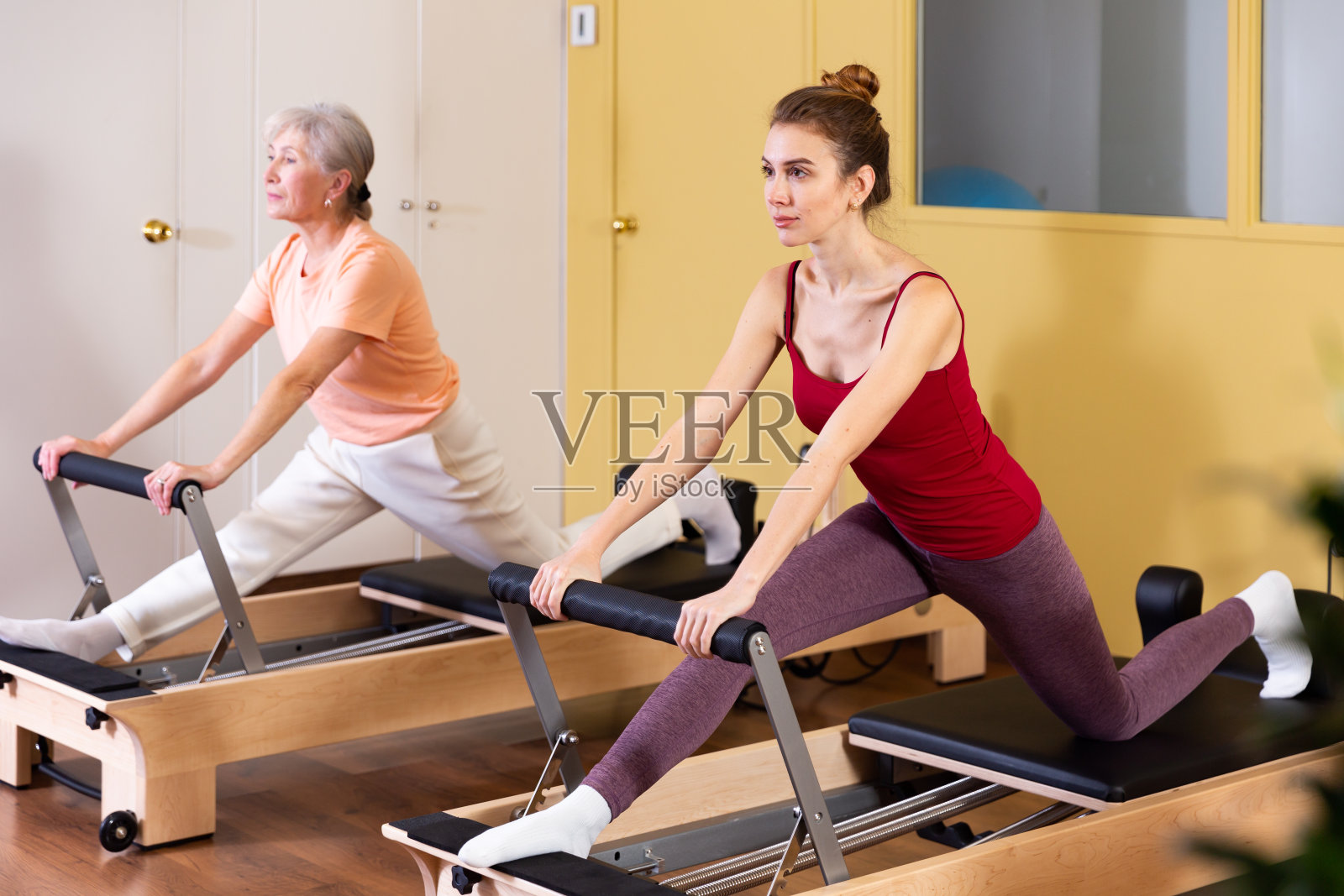 上了年纪的妇女和年轻的女孩在练习普拉提照片摄影图片