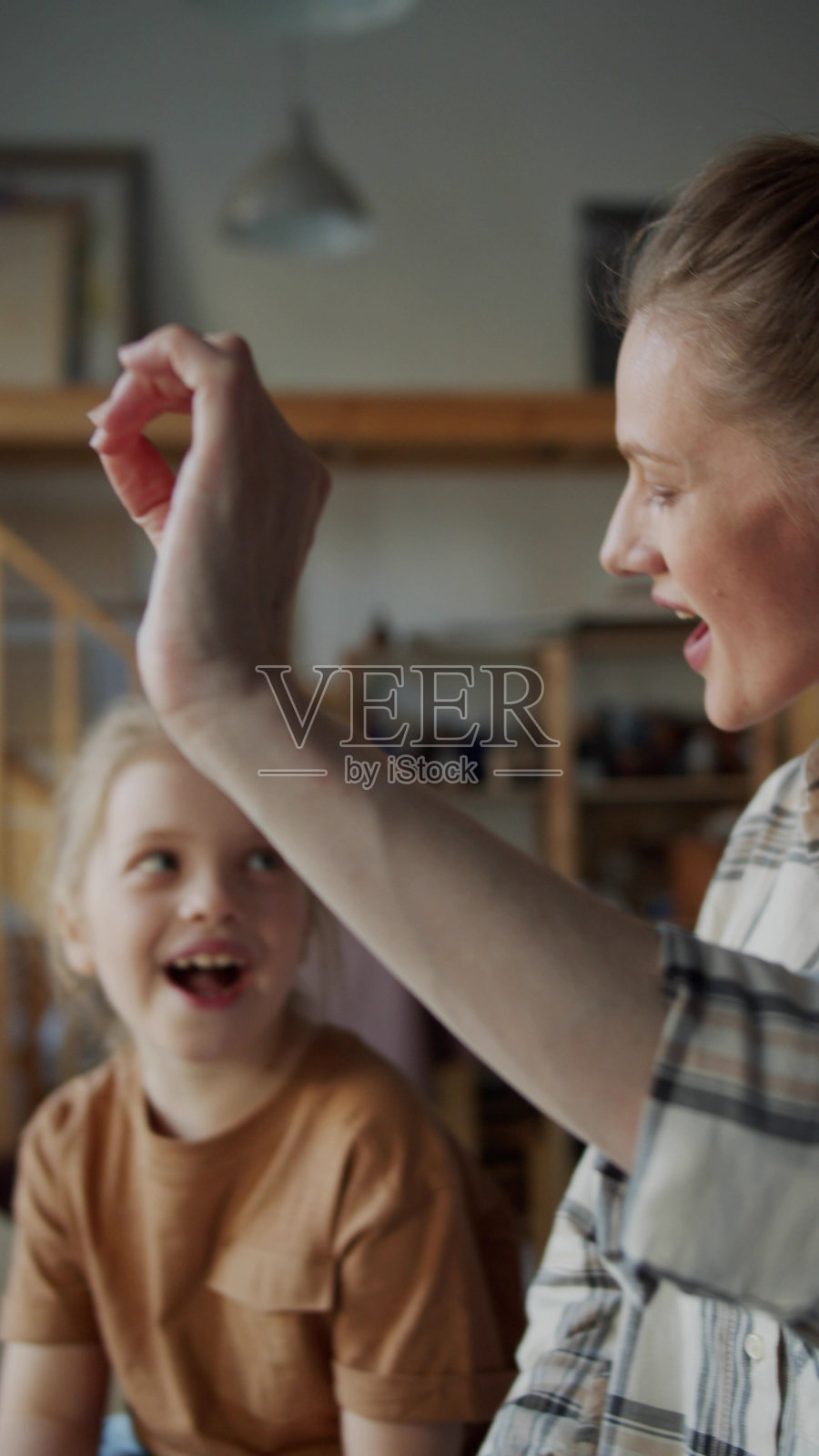 一个女孩看着一个女人唱歌，试着重复照片摄影图片