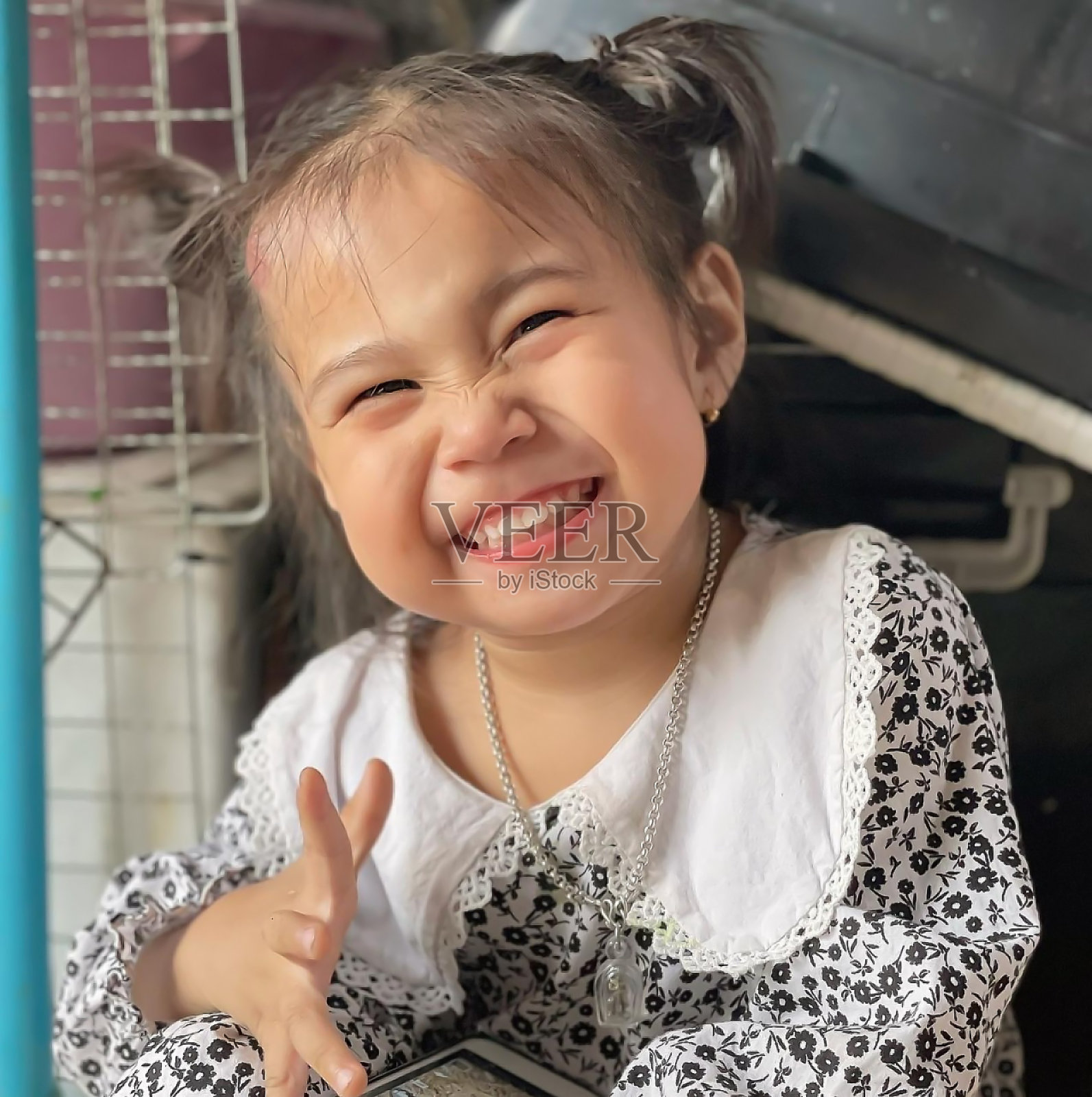 可爱的孩子亚洲妇女大笑的肖像，快乐可爱的小女孩与大大的微笑，看着相机。积极的孩子在家里摆姿势拍照，心情愉快，开朗有趣的孩子照片摄影图片