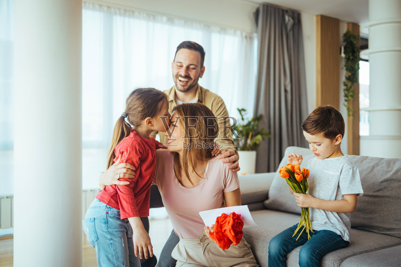 快乐的妈妈收到孩子们的礼物。照片摄影图片