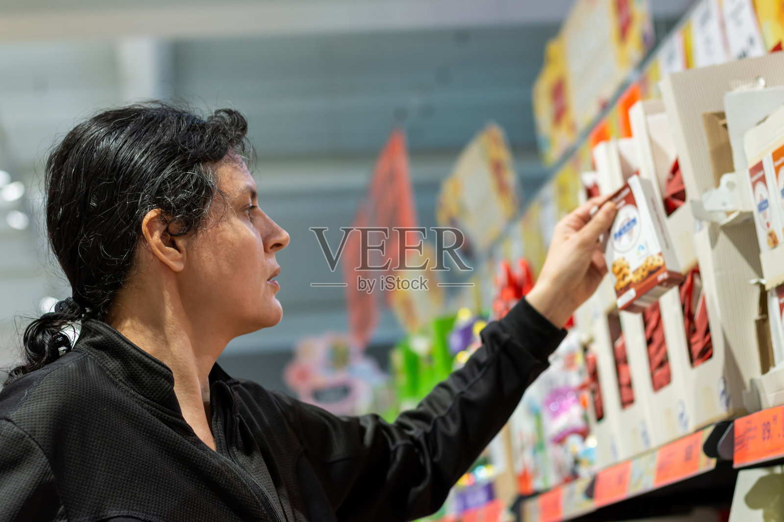 日常购物的概念。家庭主妇在超市买杂货。照片摄影图片