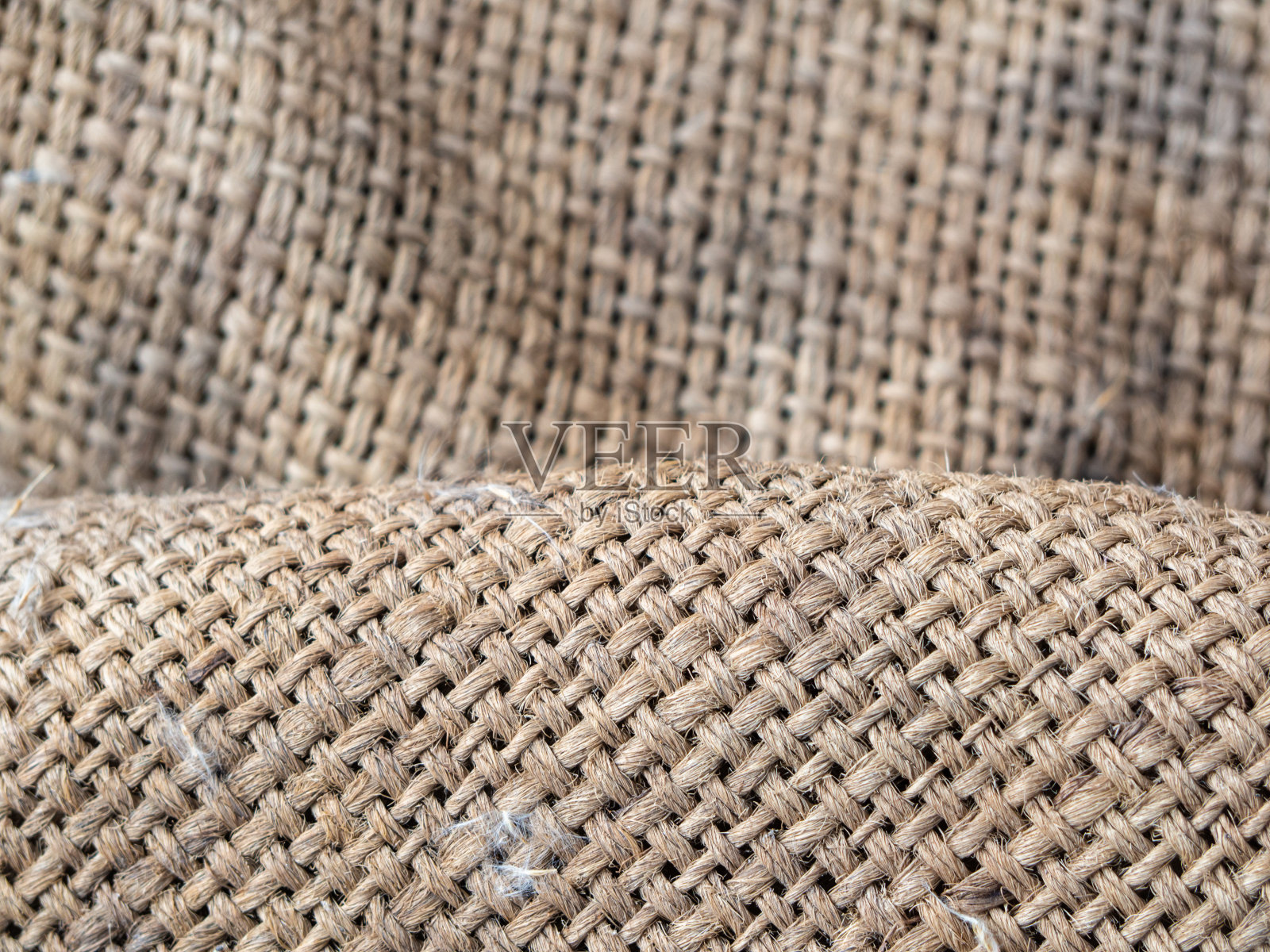 粗麻布的质地。自然老化亚麻纹理，有褶皱和阴影。自然纹理背景交织的线程与文本空间。浅棕色抽象背景照片摄影图片