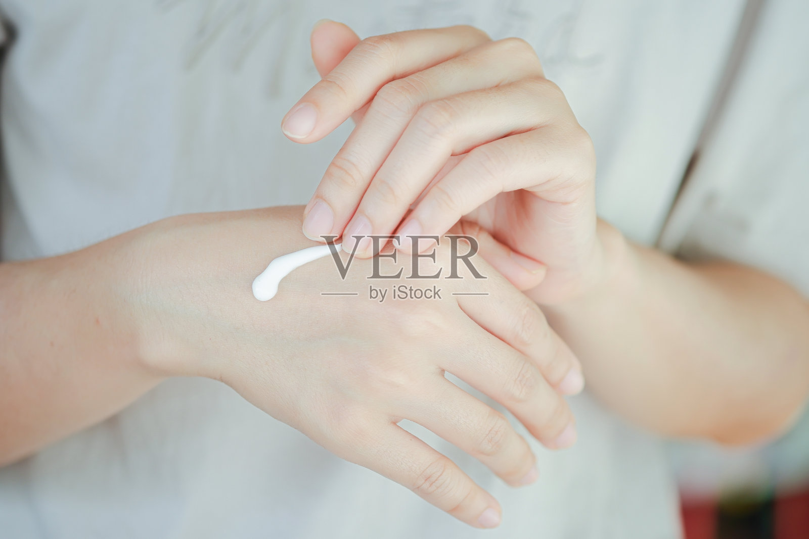涂抹于女性手部的护肤霜，增加肌肤水分。手部保健的概念。照片摄影图片