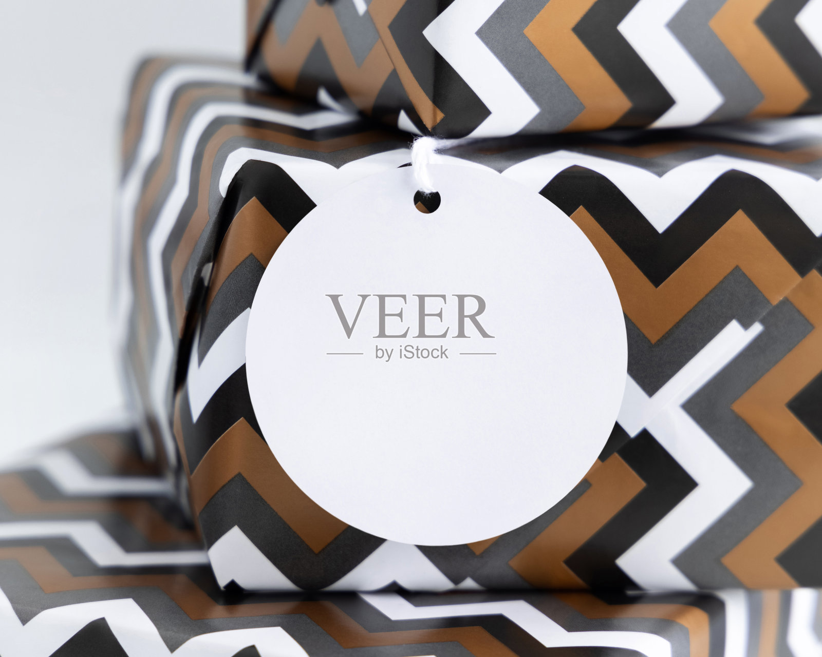 礼物包装在雪佛龙纸与空白礼物标签接近，标签模型照片摄影图片