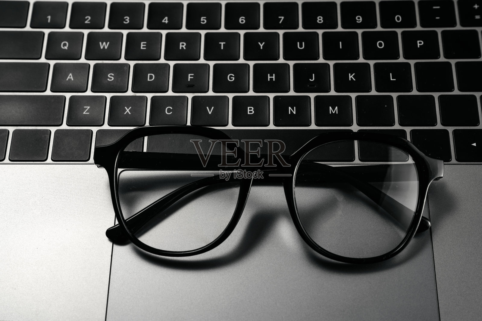 白色背景的电脑和眼镜照片摄影图片