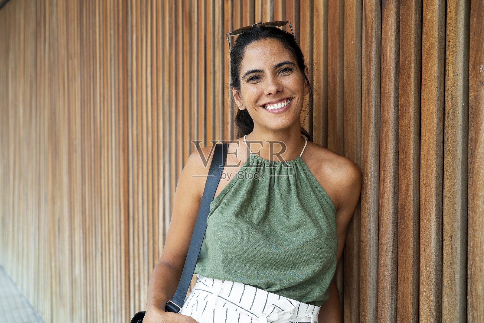 微笑的墨西哥女人站在木墙的肖像照片摄影图片
