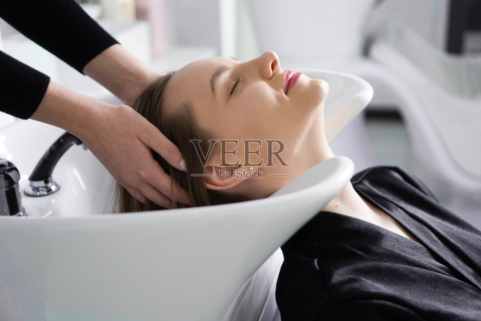 美发师在美发厅给顾客洗头发照片摄影图片