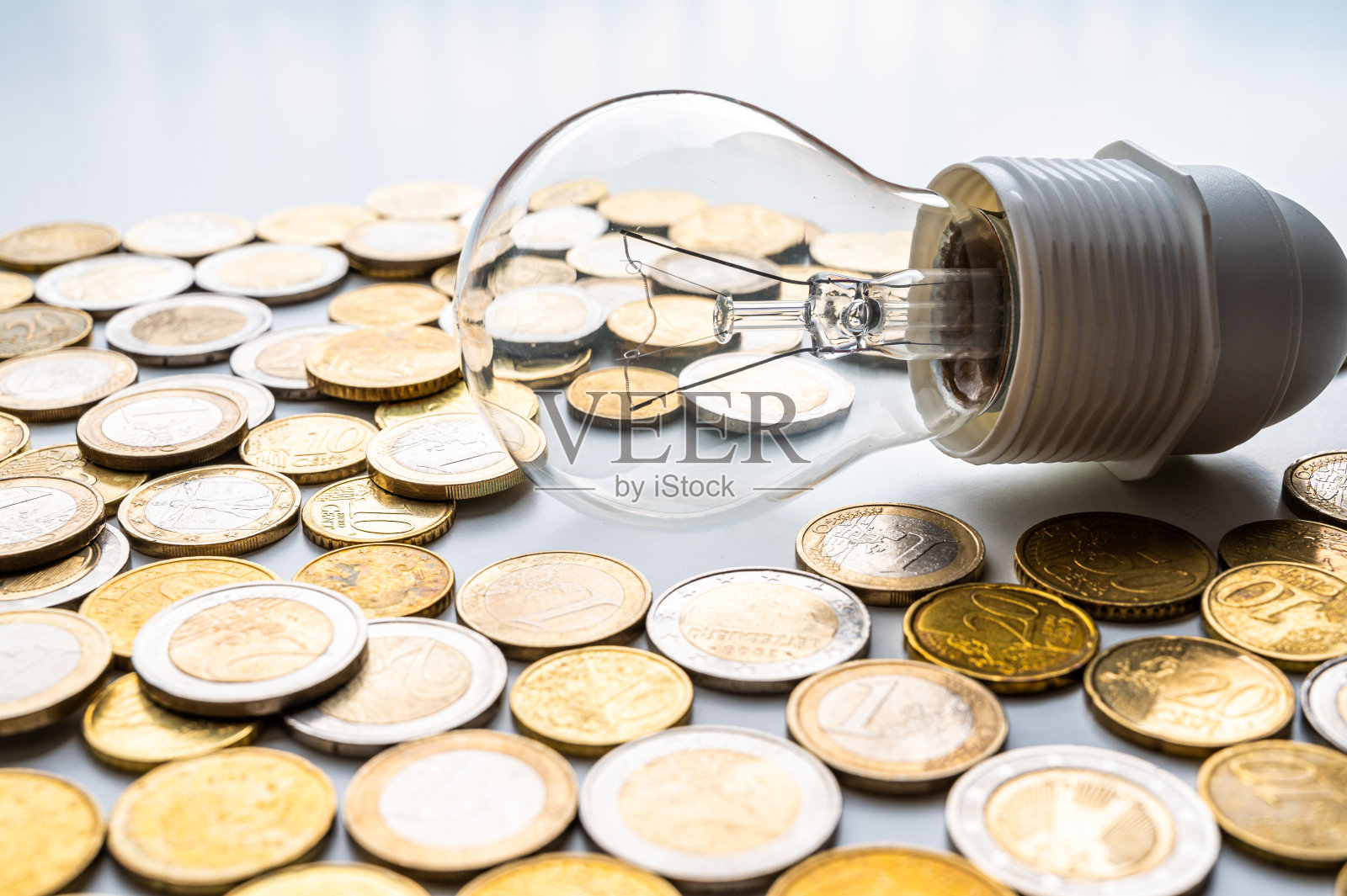 周围有硬币的灯泡。能源成本。照片摄影图片