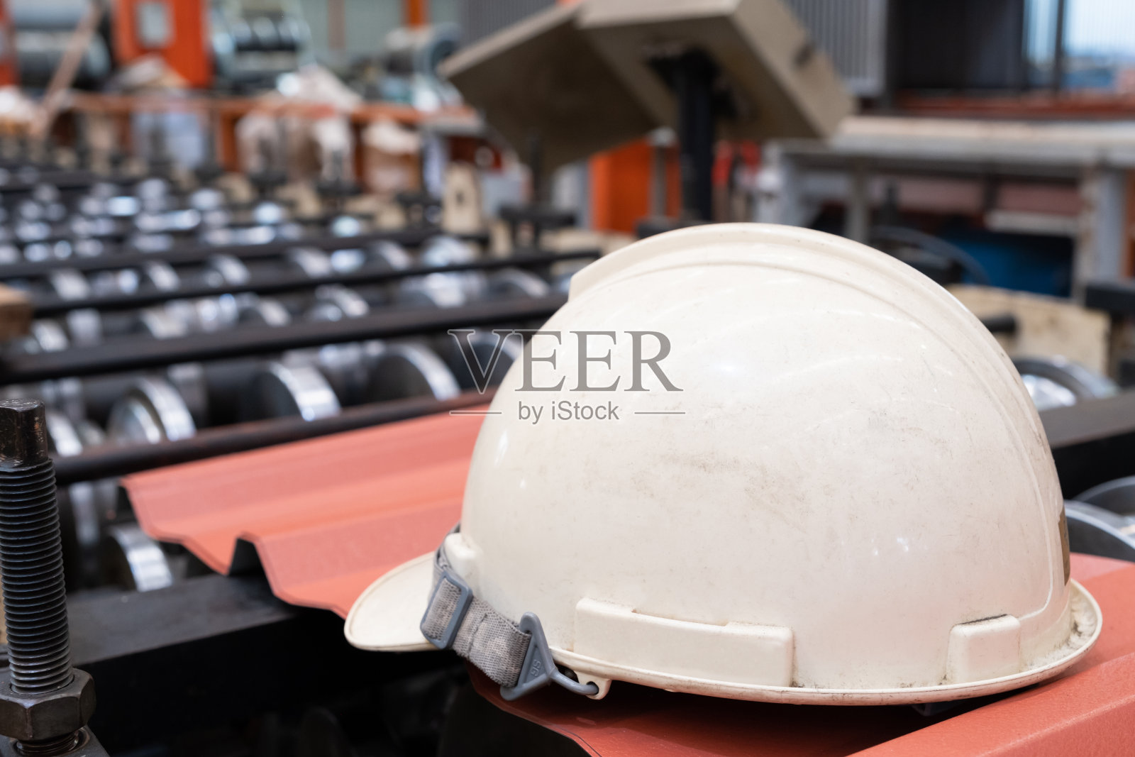 对工厂生产线内安装在重型机械上的安全安全帽进行选择性关注。工业领域的安全防护装备概念，以防止工人受伤或事故。照片摄影图片