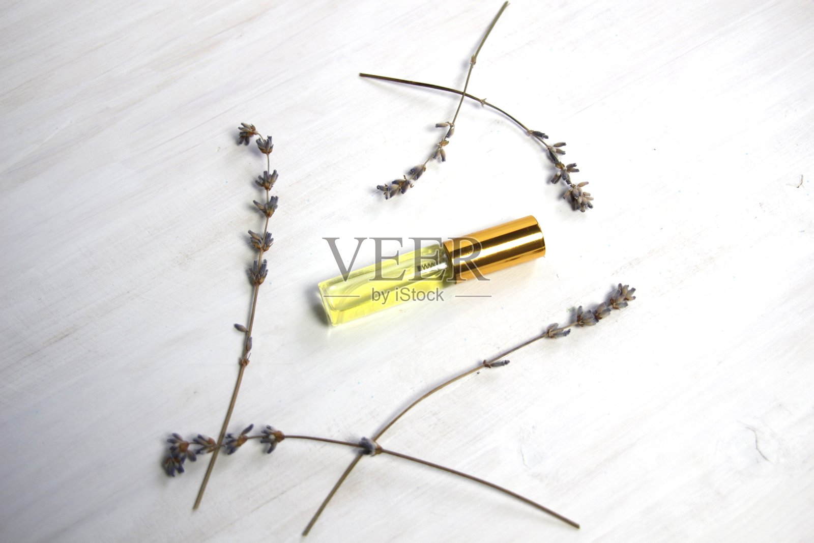 玻璃香水瓶与金色顶部和干薰衣草花在白色背景照片摄影图片