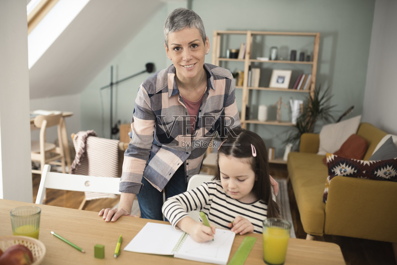 一个快乐的母亲帮助她的小女孩数学的肖像照片摄影图片