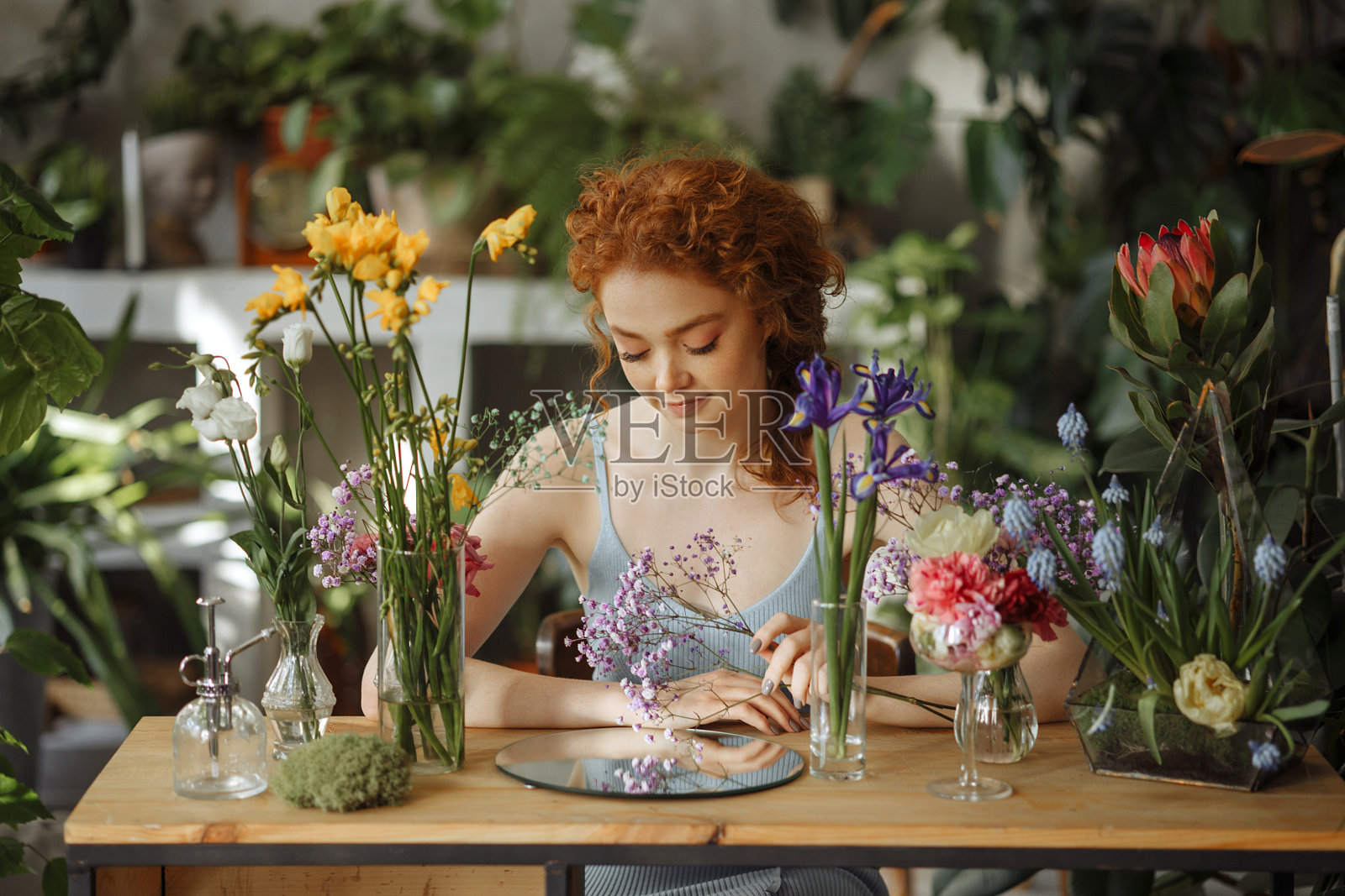 年轻女子和花瓶里的鲜花照片摄影图片