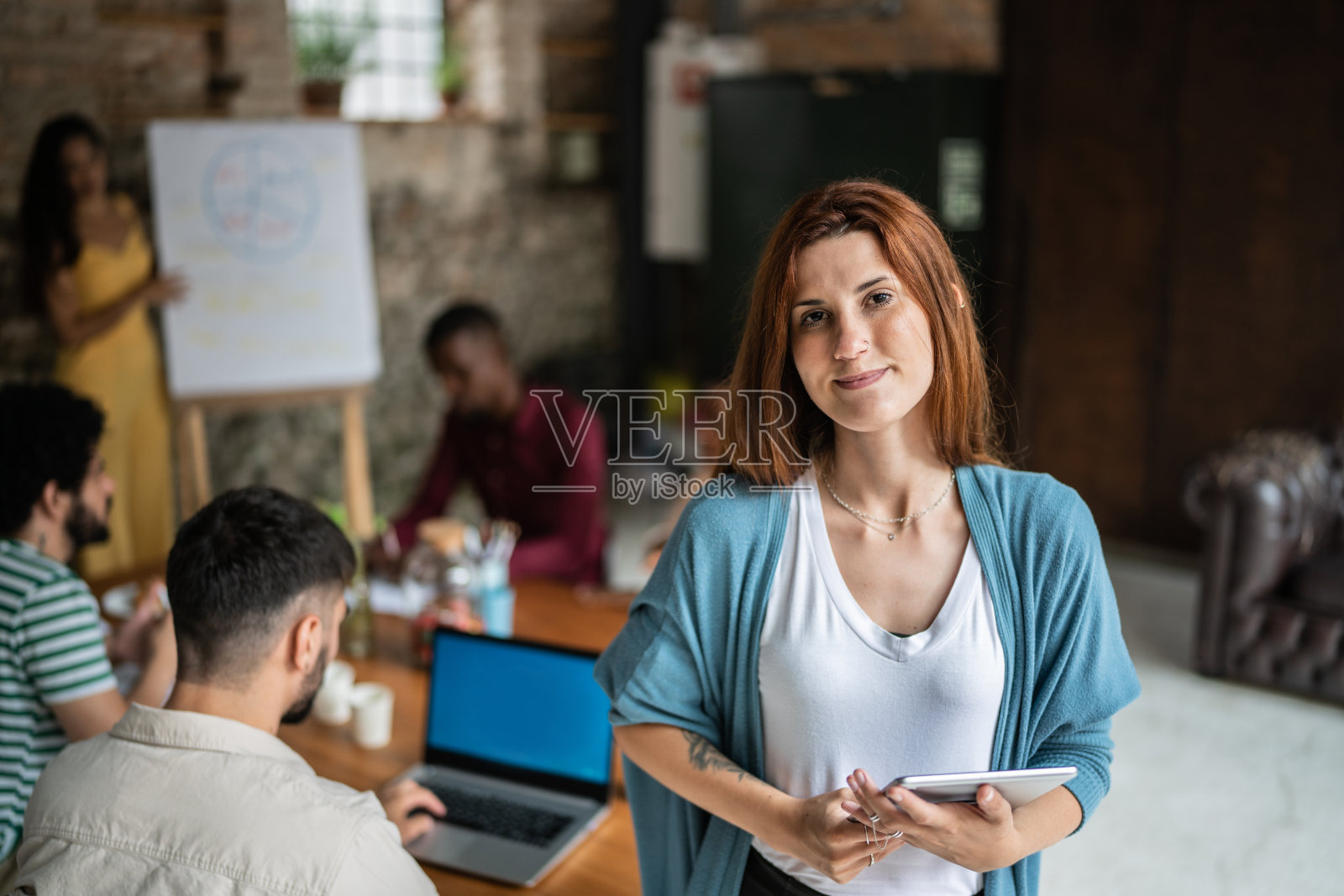 一名年轻的女商人在办公室里手持数码平板电脑的肖像照片摄影图片