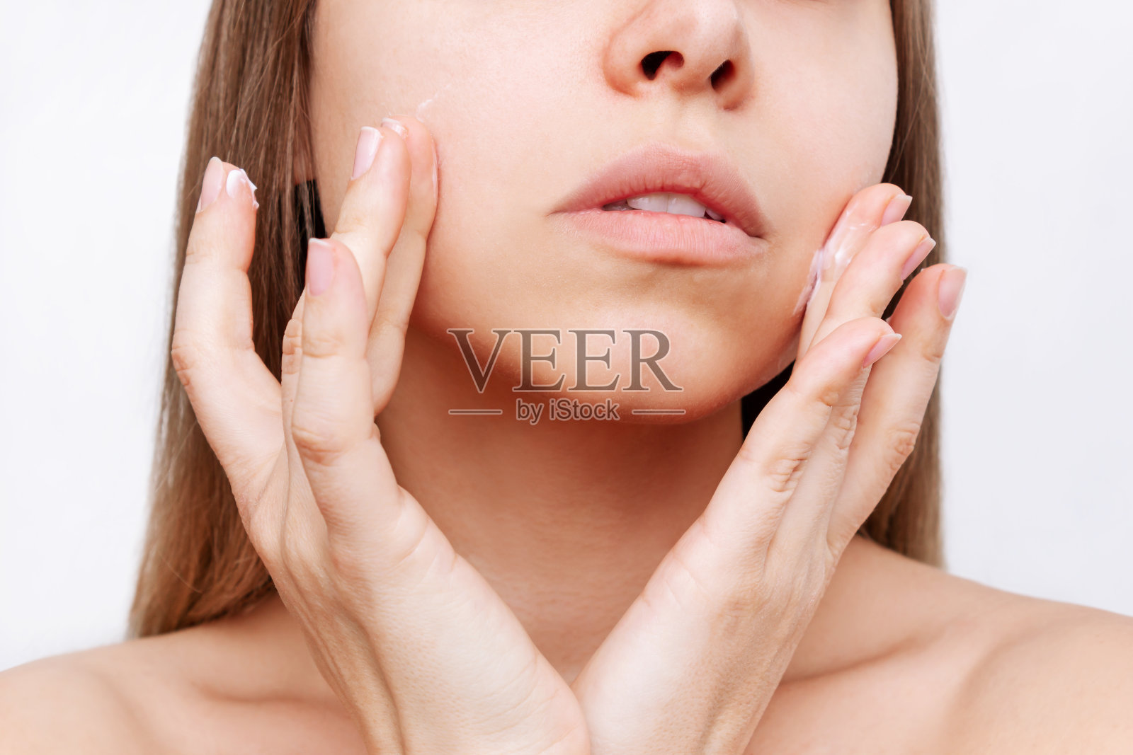 年轻迷人的白种人金发女人触摸脸与她的手应用保湿霜照片摄影图片