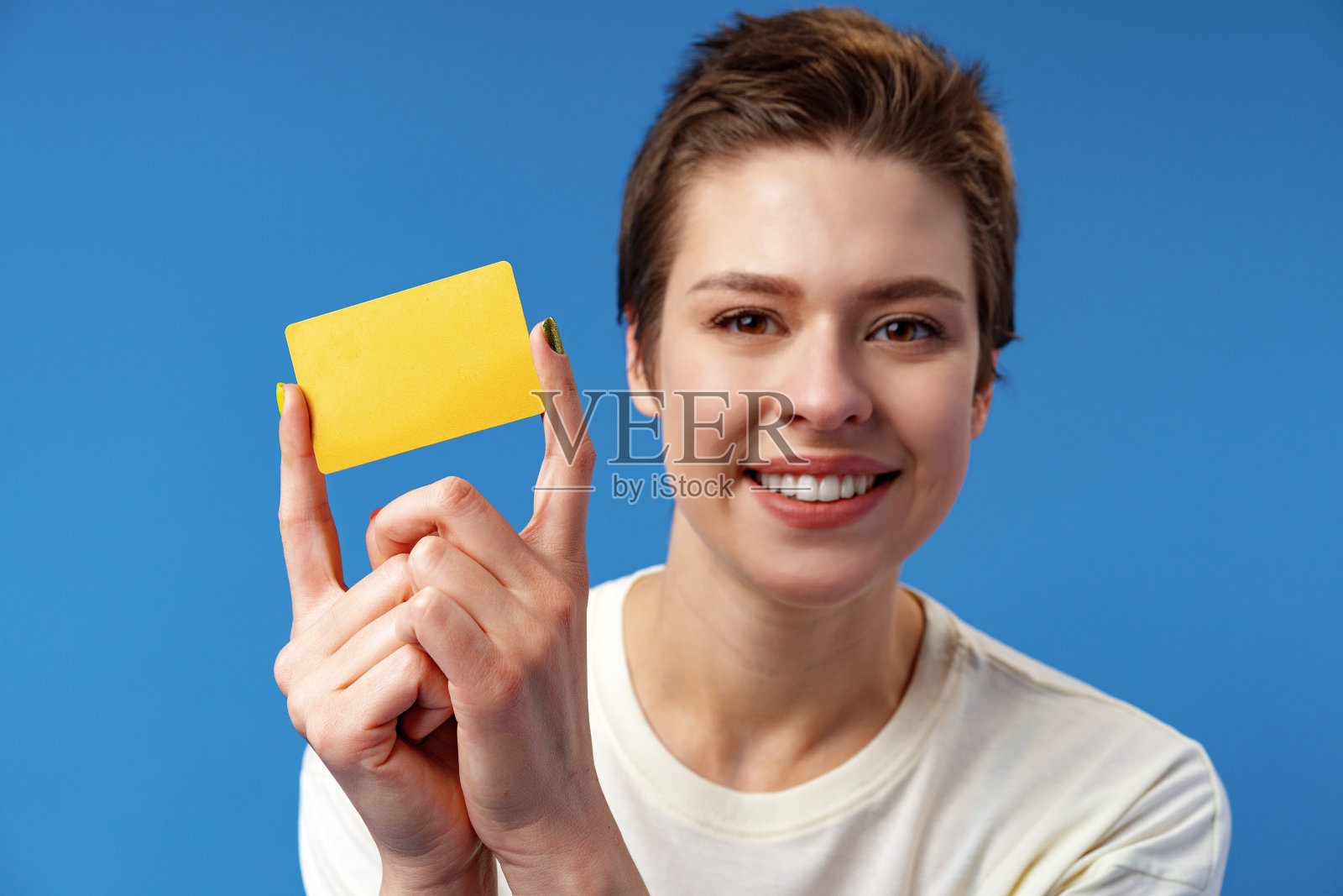 年轻女子的形象，拿着名片的复印空间在蓝色背景照片摄影图片