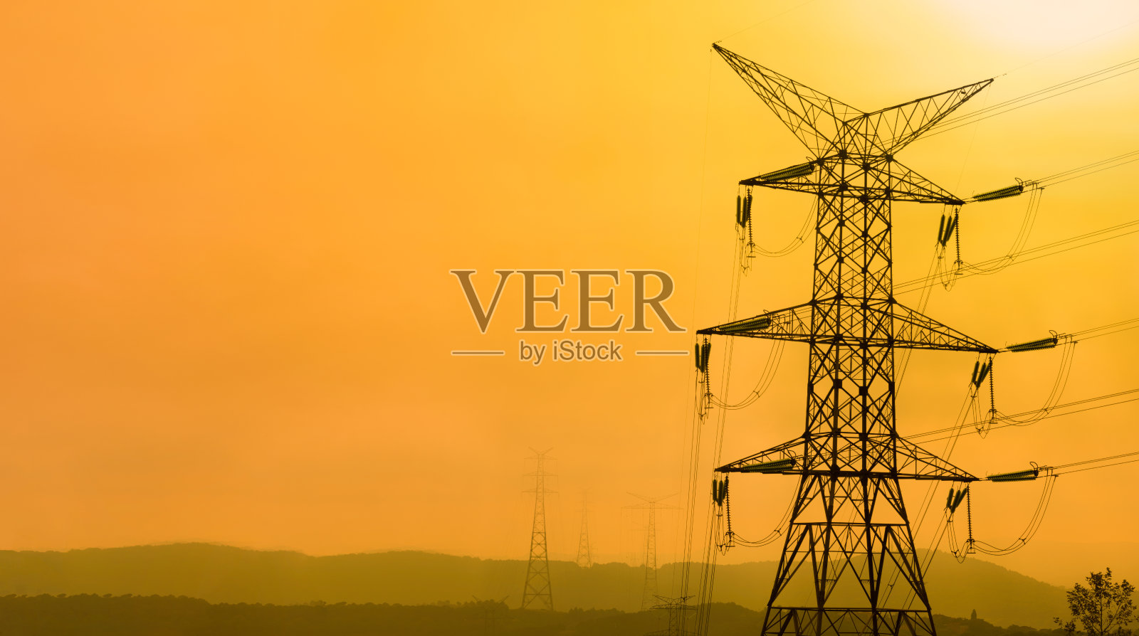 日落时的高压电线。照片摄影图片