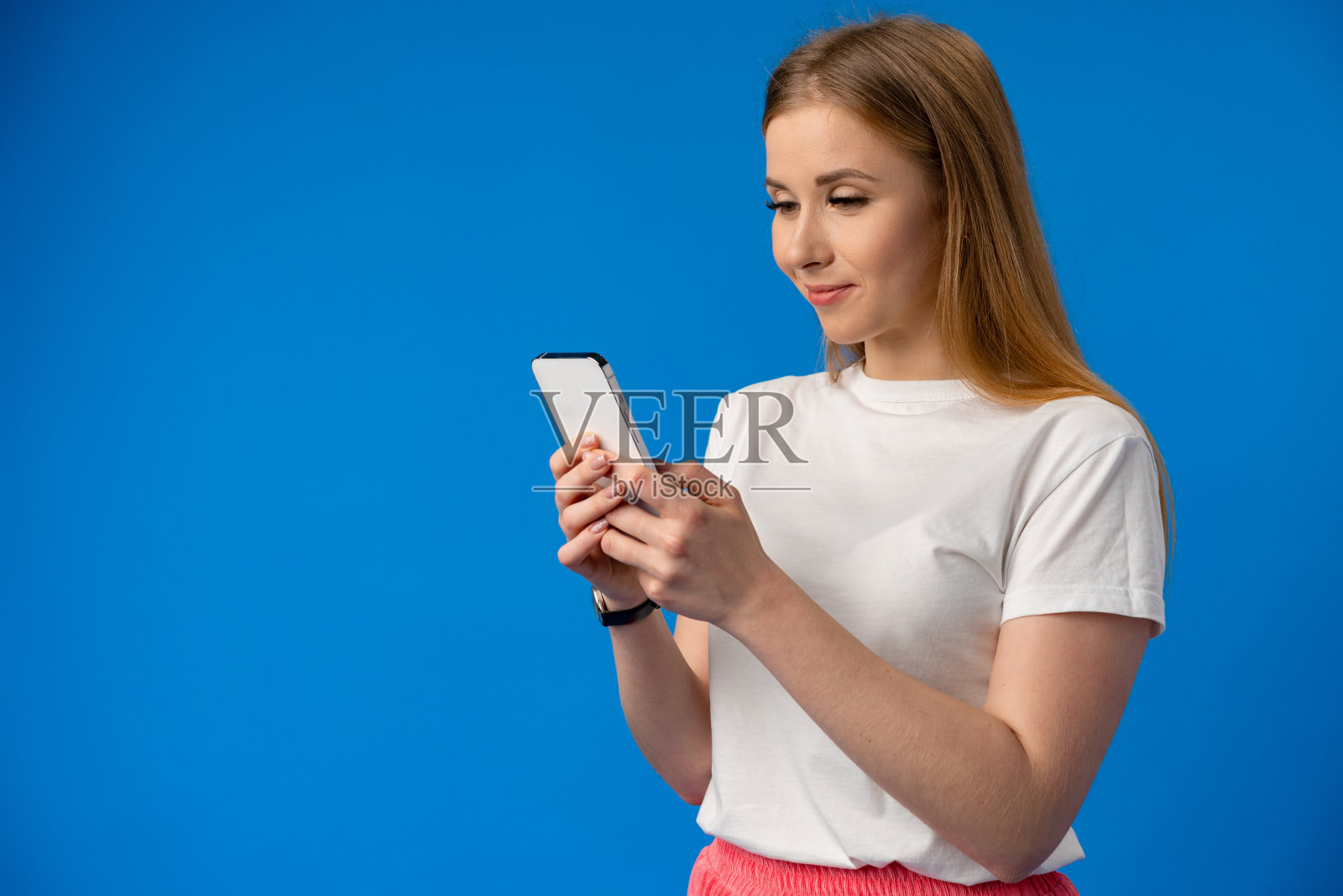 一个年轻女人的肖像使用手机的颜色背景。照片摄影图片