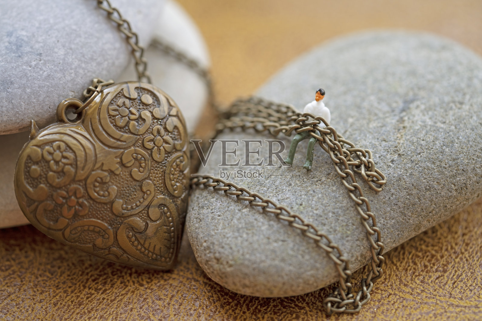 鹅卵石上经典的心形和链子，以浪漫爱情的含义为背景照片摄影图片