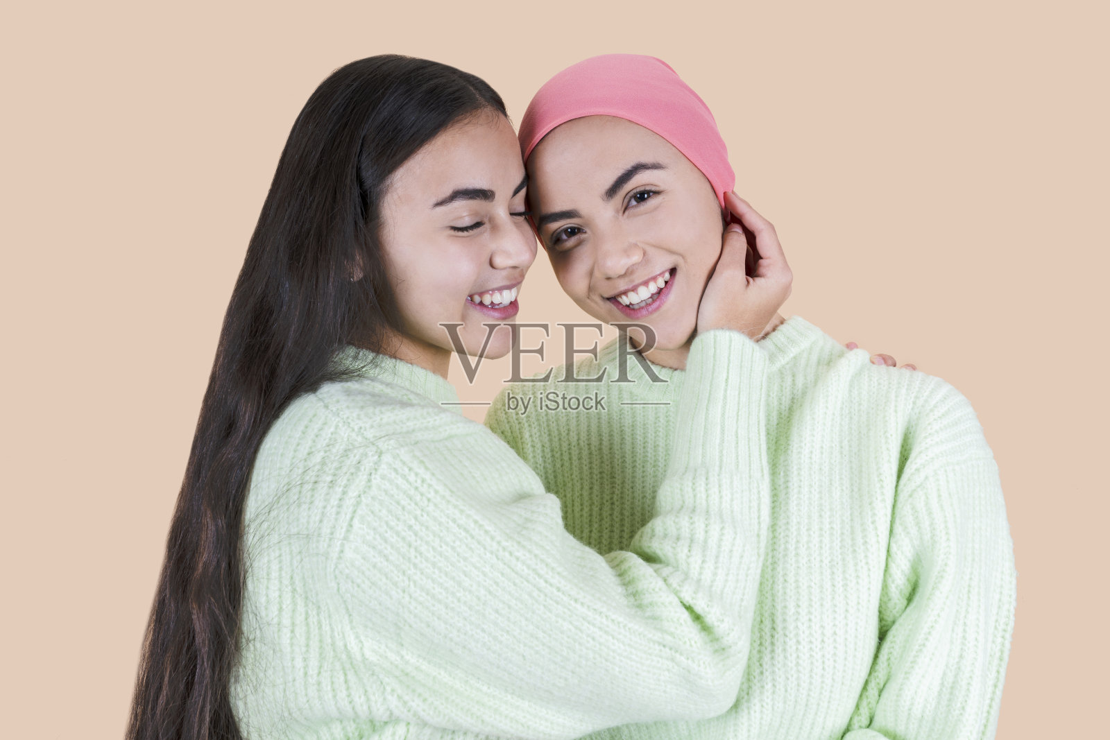 戴着粉色围巾与癌症抗争的女人，彼此相爱的姐妹，化疗后的乐观照片摄影图片