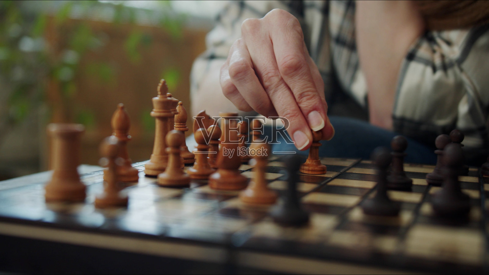 一个女人在棋盘上移动棋子。大特写镜头照片摄影图片