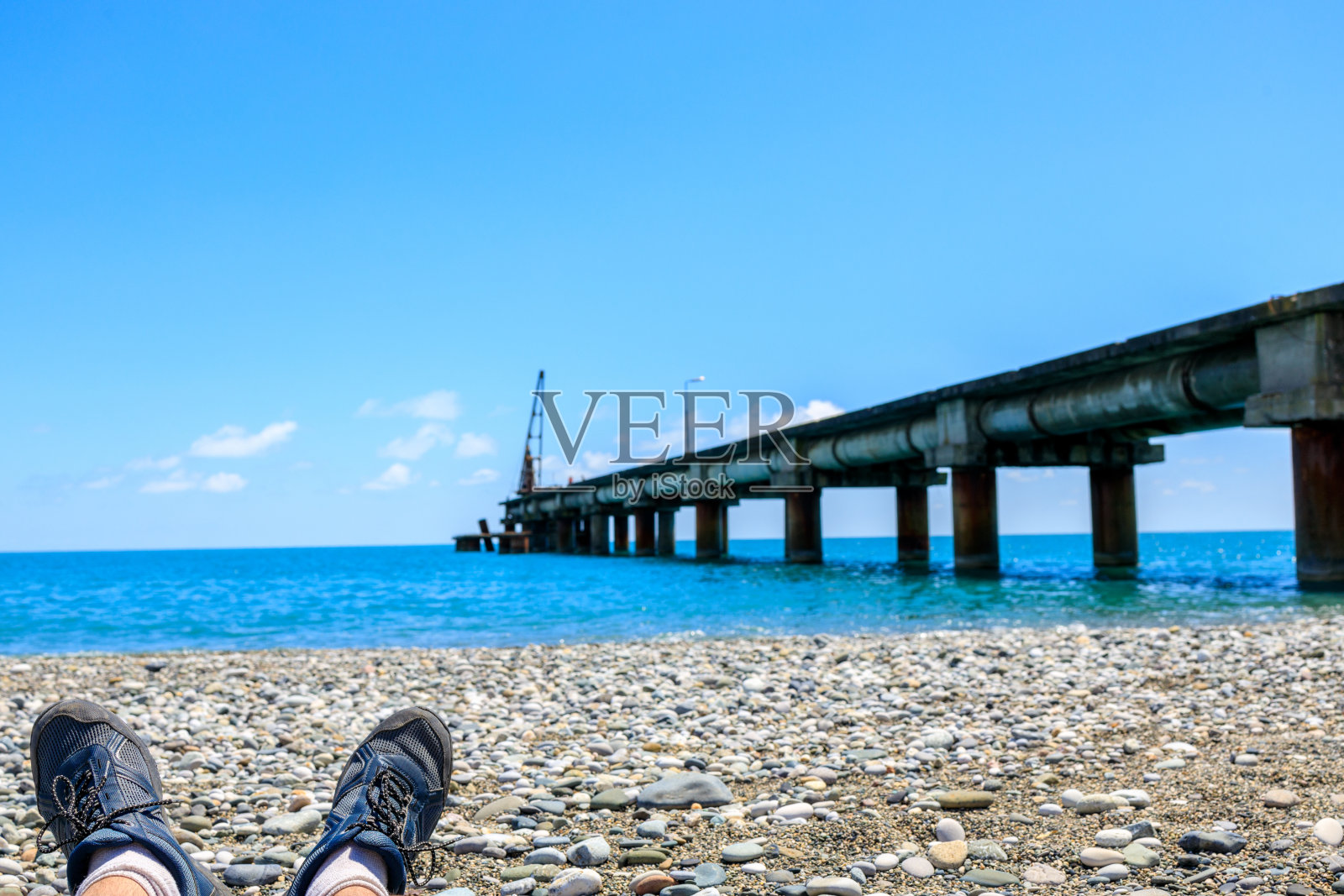 在海边休息，两腿人在前景照片摄影图片