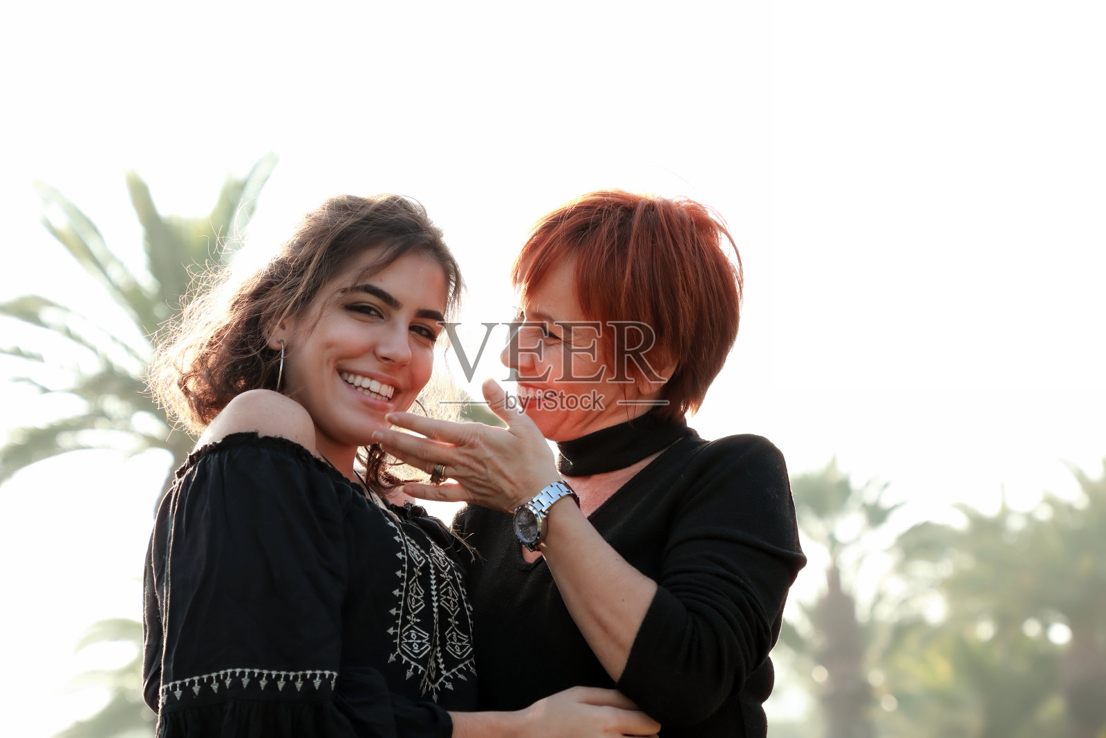 快乐的单身母亲和年轻的成年女儿在公园的户外肖像照片摄影图片