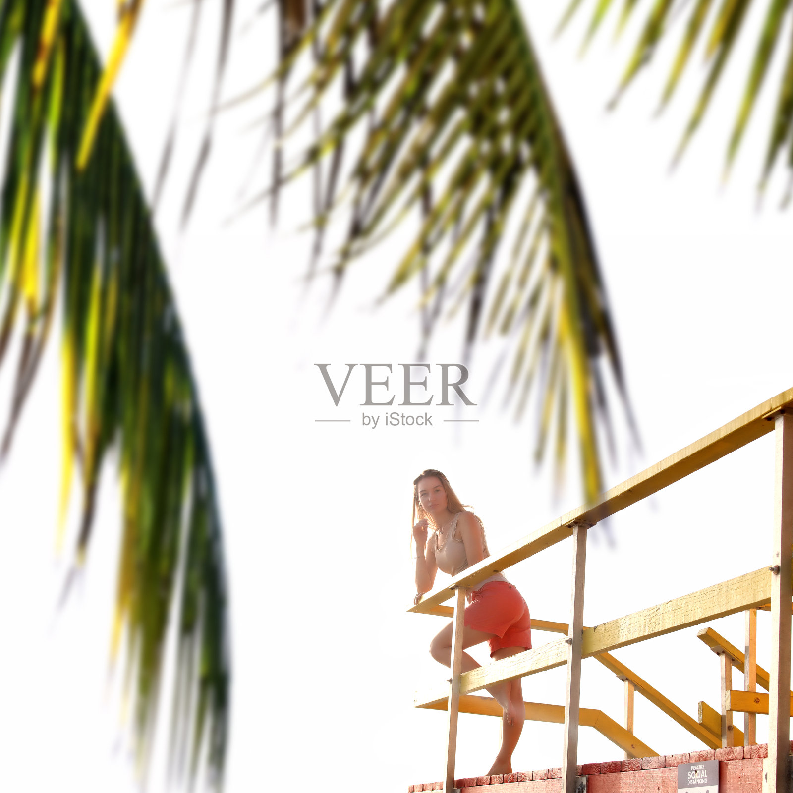 美丽快乐的年轻金发女人在阳光明媚的早晨在海滩的天空照片摄影图片