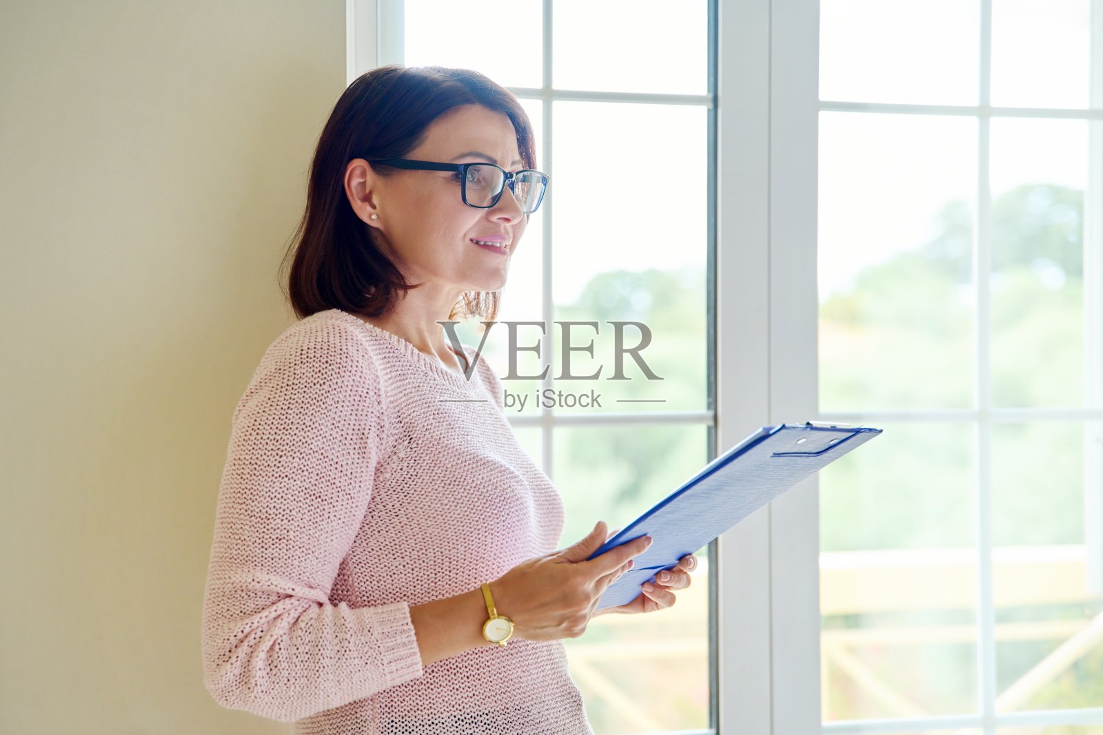 一个女人的肖像与一个文件夹阅读文件。照片摄影图片