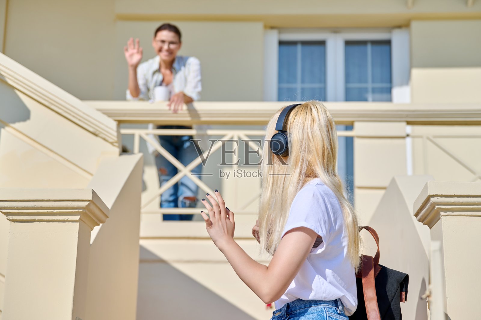 一位中年母亲在门廊上送她十几岁的女儿照片摄影图片