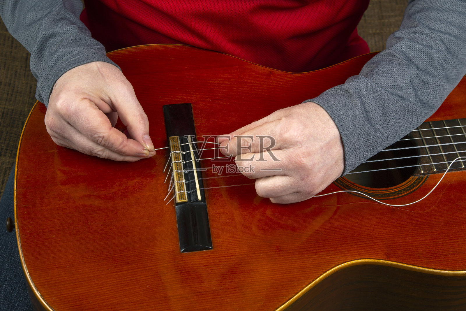 替换和插入尼龙弦在古典吉他。给音乐家的一课照片摄影图片