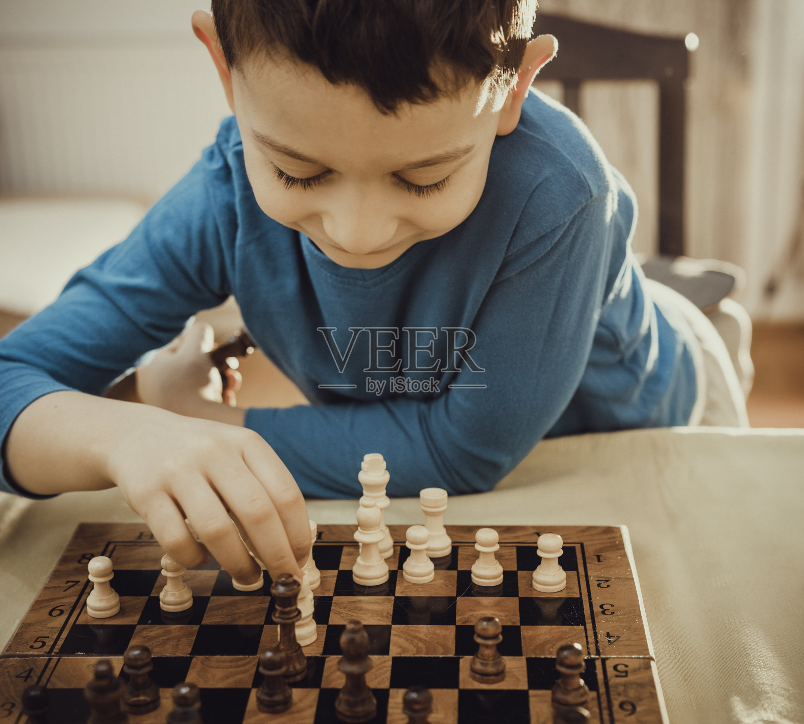 男孩和姐姐在家里下棋照片摄影图片