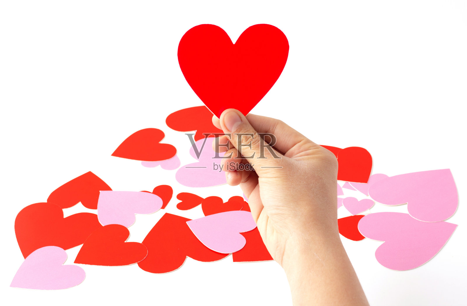 手拿一个红心形状的纸工艺品孤立在白色的背景上。照片摄影图片