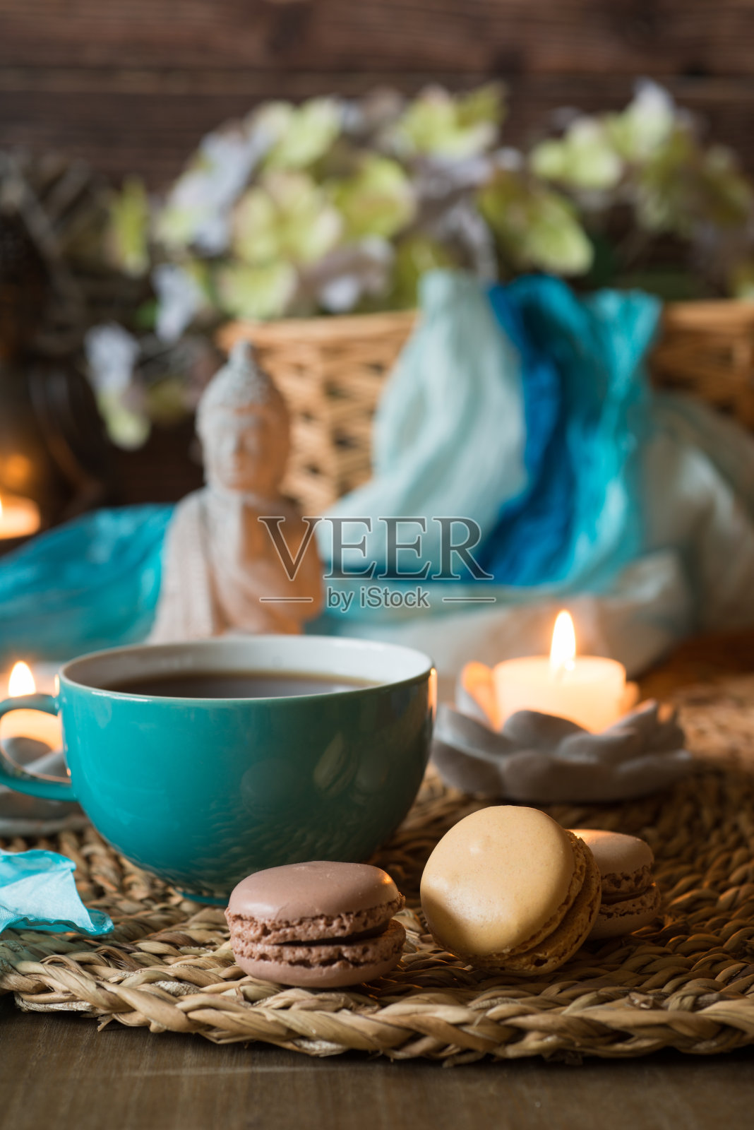 茶或咖啡在杯子和马卡龙与佛陀和烛光休息照片摄影图片