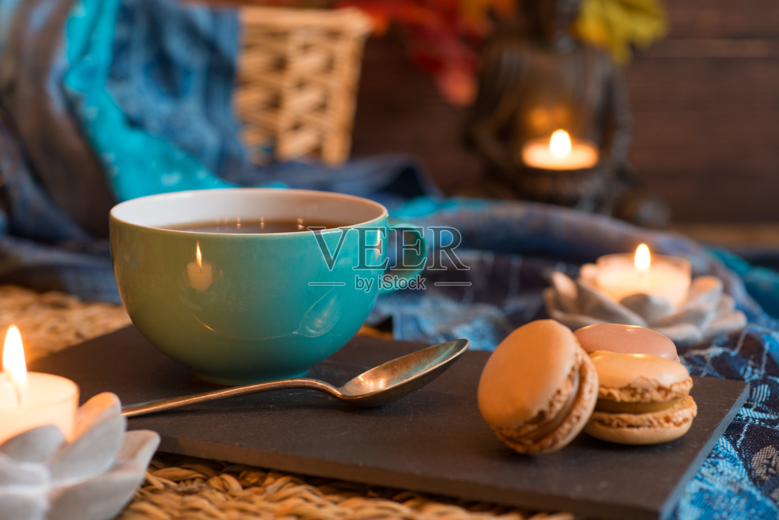 茶或咖啡在杯子和马卡龙与佛陀和烛光休息照片摄影图片