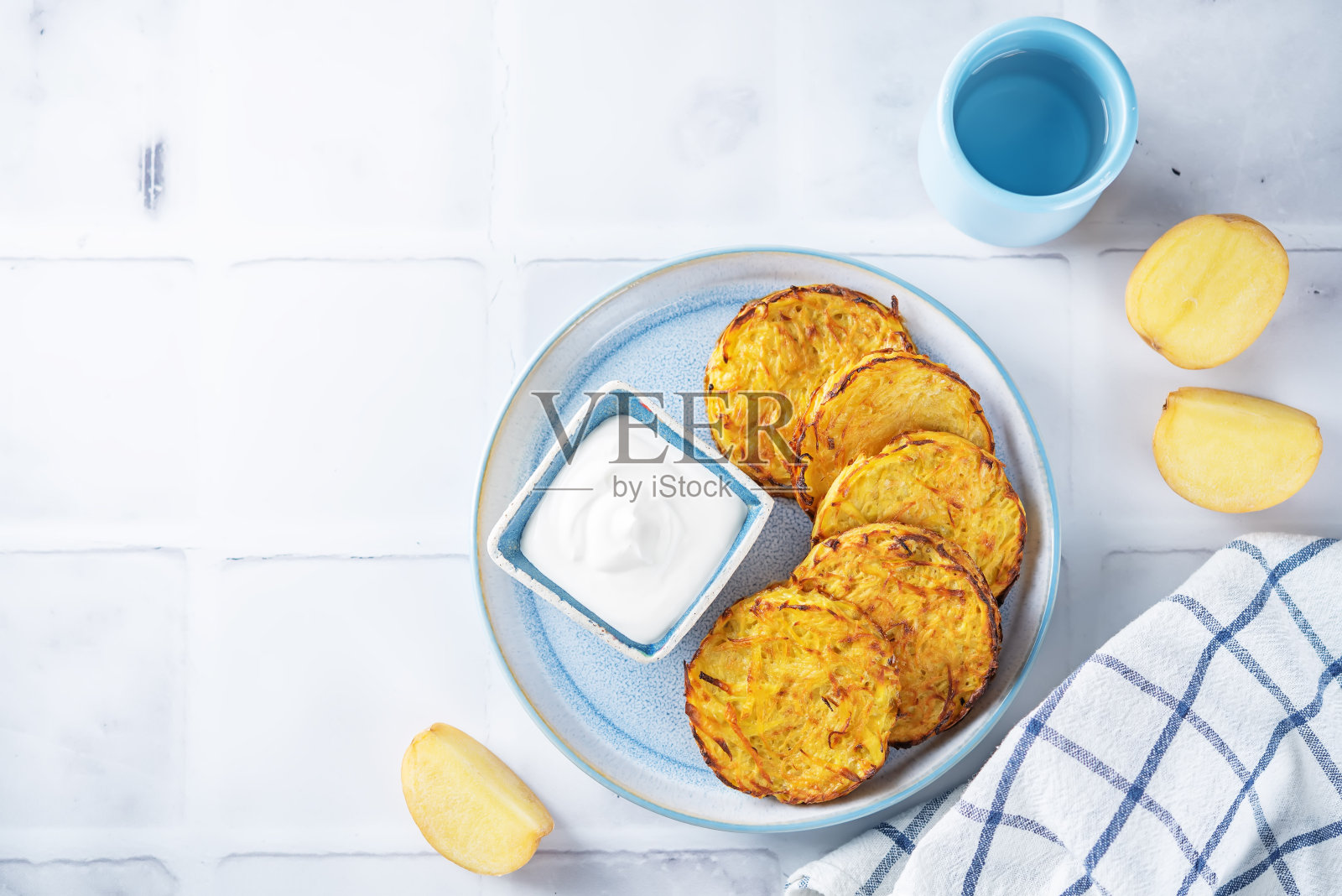 土豆煎饼配酸奶油酱放在盘子里照片摄影图片