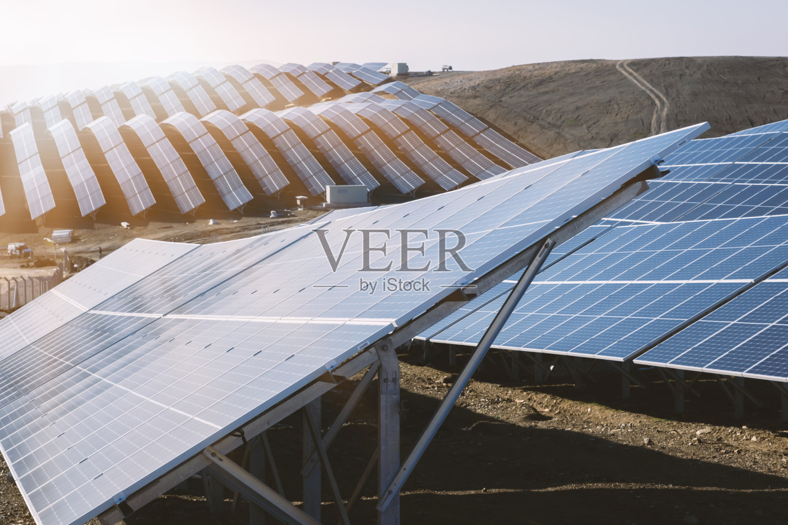 太阳电池板与日落和蓝天背景。清洁能源概念照片摄影图片