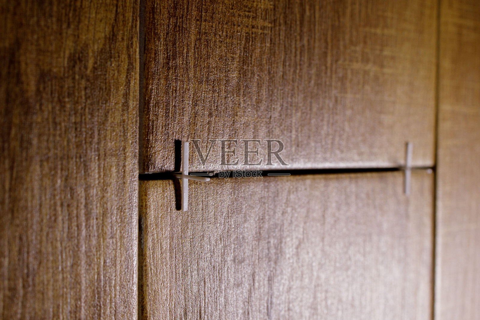 在墙面覆层过程中，用十字作为瓷砖的帮助来铺设瓷砖照片摄影图片