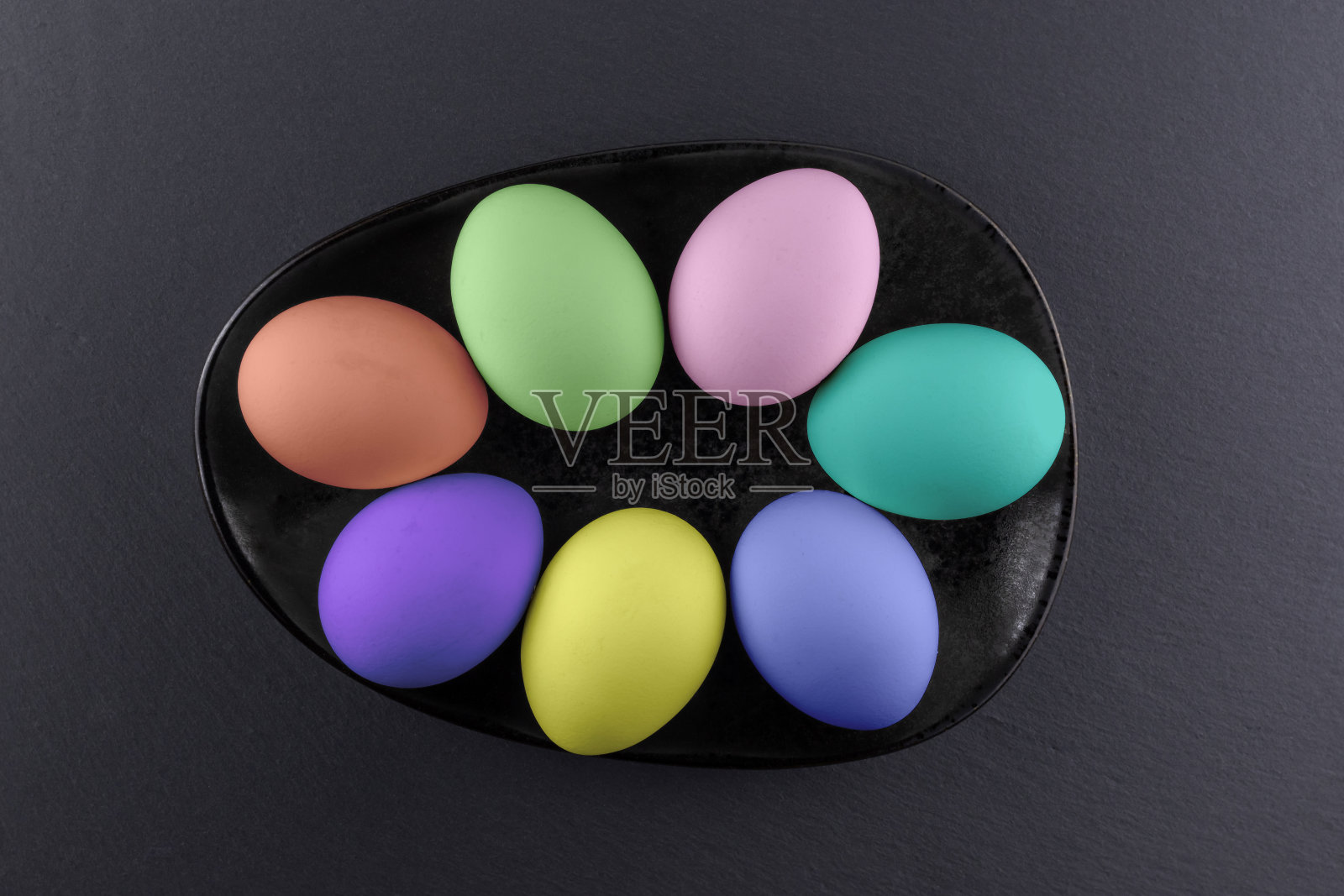 在黑色的石头背景上的彩色复活节彩蛋。复活节的抽象概念照片摄影图片