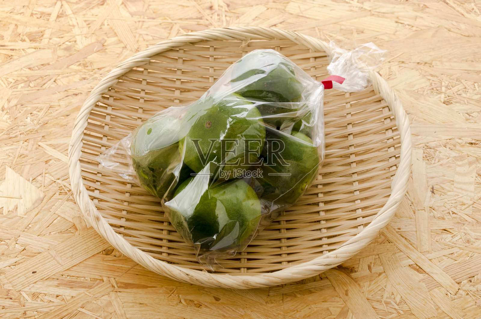 柑橘温湿，蜜橘在胶合板背景的塑料袋照片摄影图片