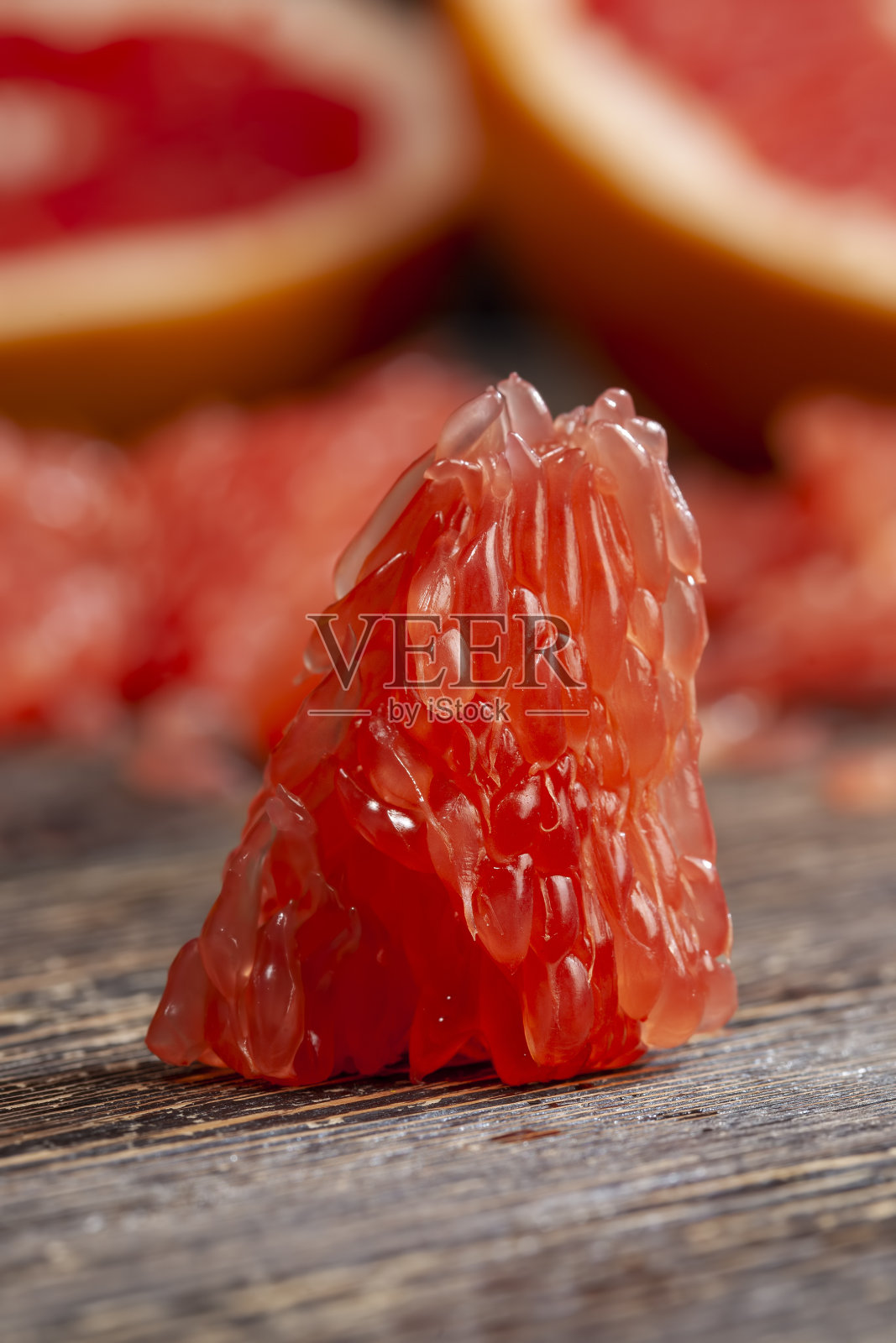 用餐时，木桌上放几片红葡萄柚照片摄影图片