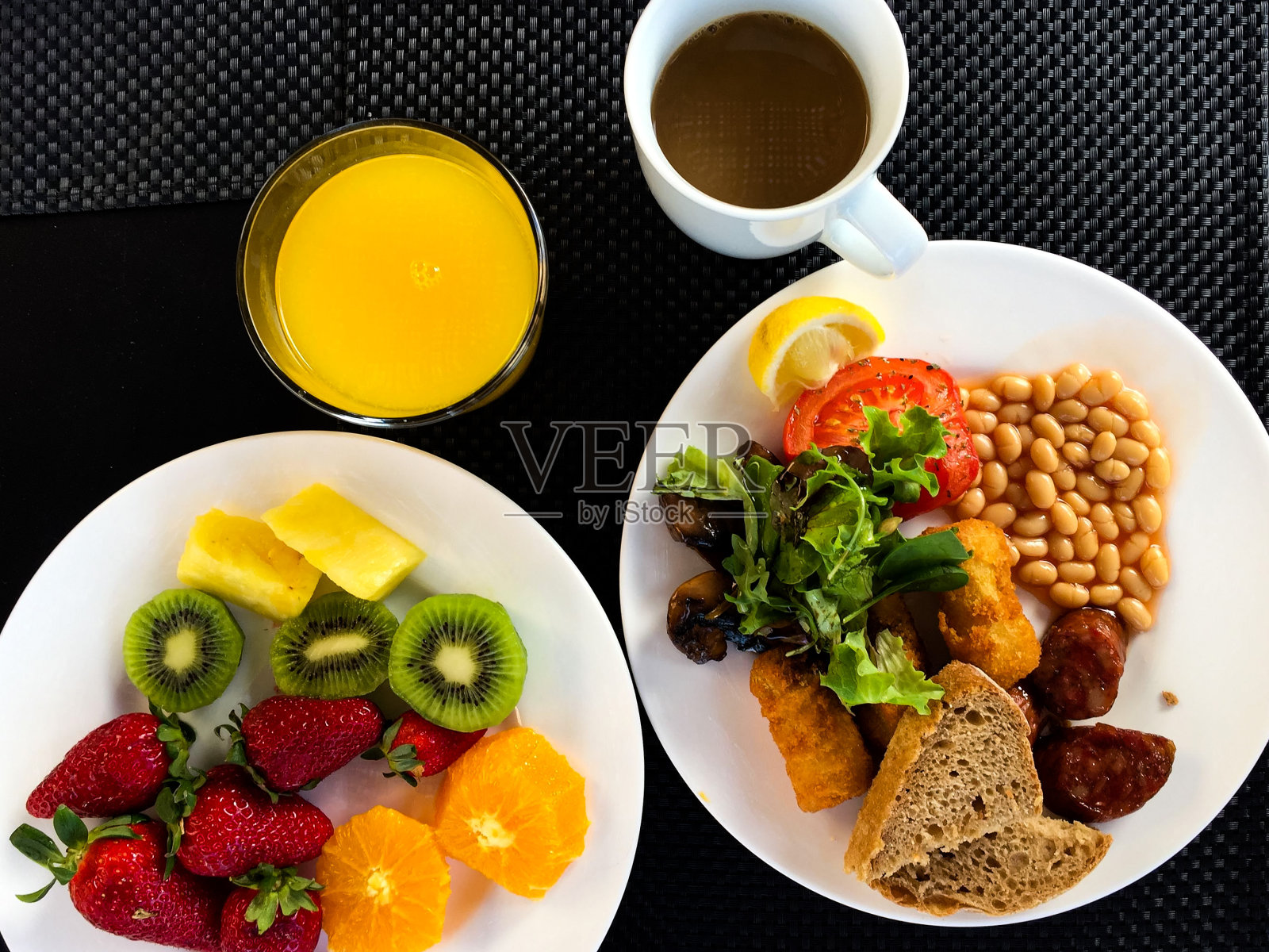 早餐时间。健康的早餐。英式早餐。浆果和水果，糕点，咖啡在黑色的背景照片摄影图片