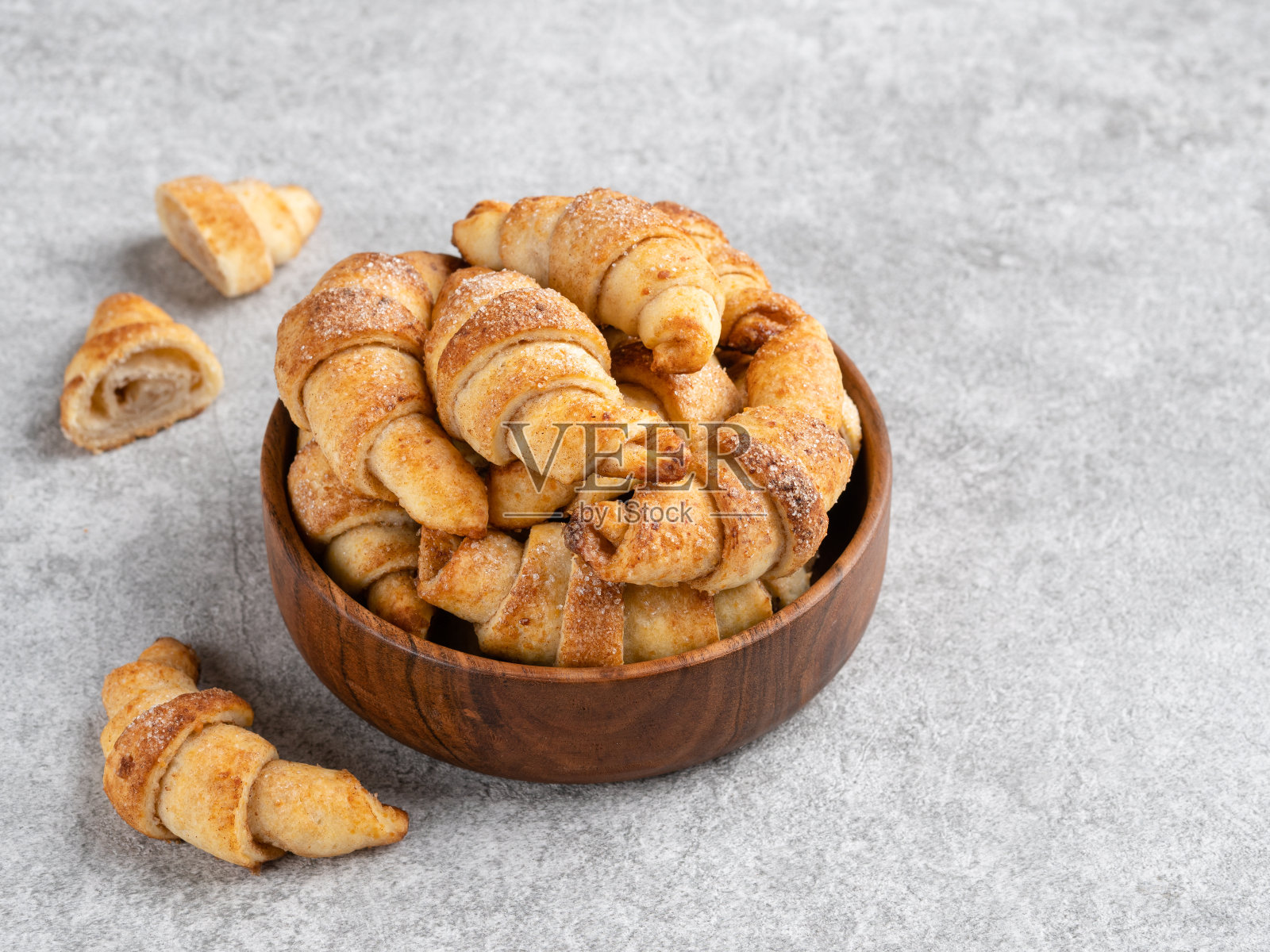 新月形饼干卷装在棕色木碗里。肉桂糖饼干。特写视图。副本的空间。照片摄影图片
