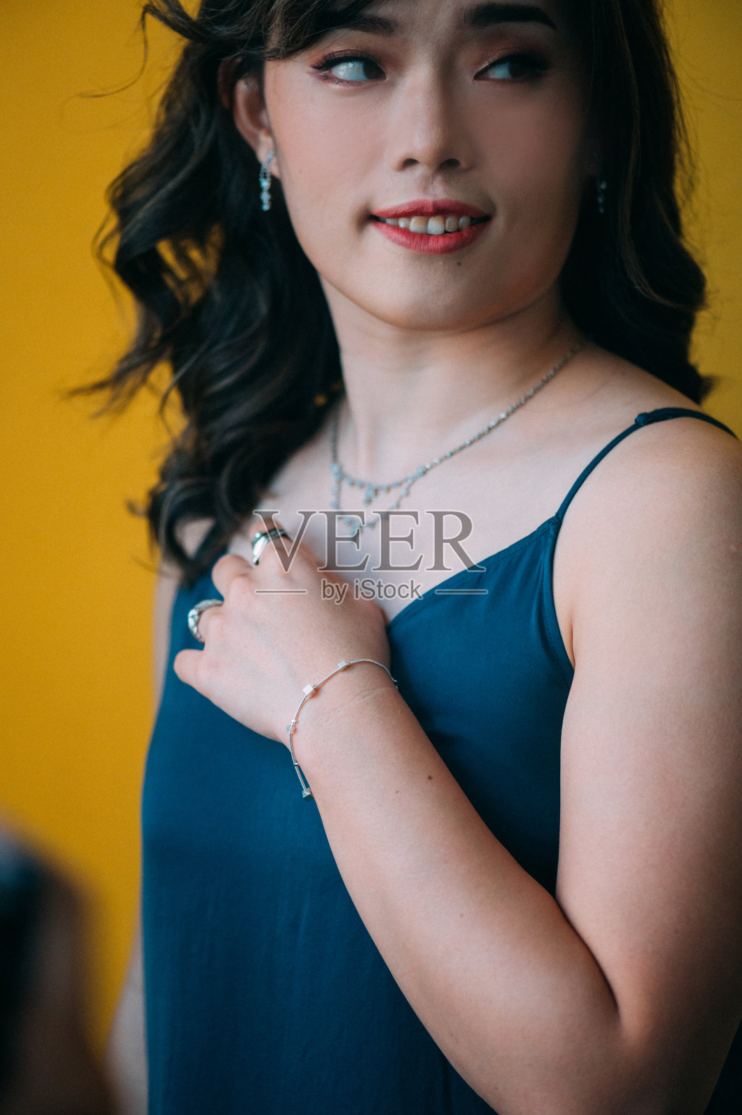 美丽的亚洲女人的肖像穿着一套时髦的珠宝，钻石戒指，项链，手镯和耳环照片摄影图片