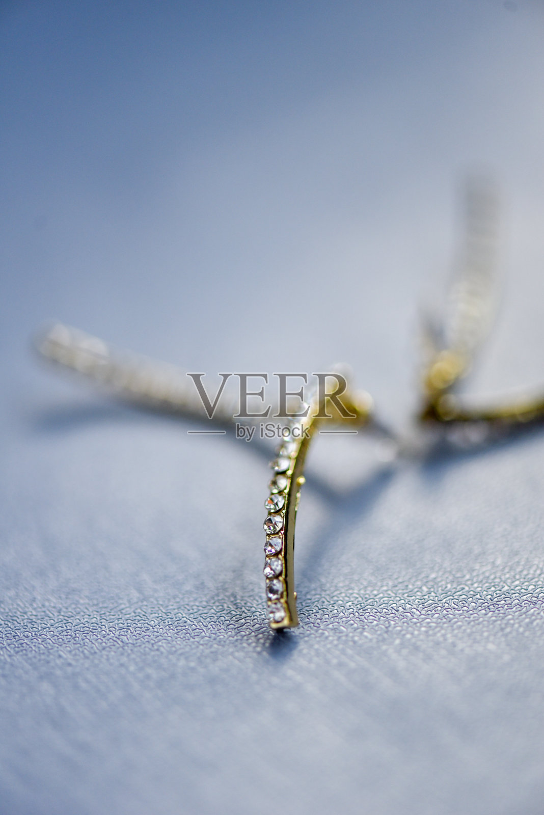 黄金耳环，蓝色背景的钻石眼睛照片摄影图片