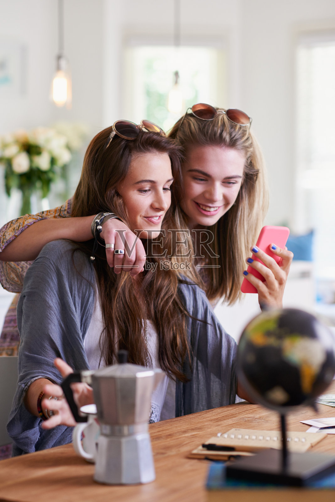 两名年轻女性在家里一起使用智能手机的照片照片摄影图片